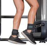 Tobillera Innove Pilates utilizada en máquina de polia baja durante entrenamiento de piernas y glúteos.