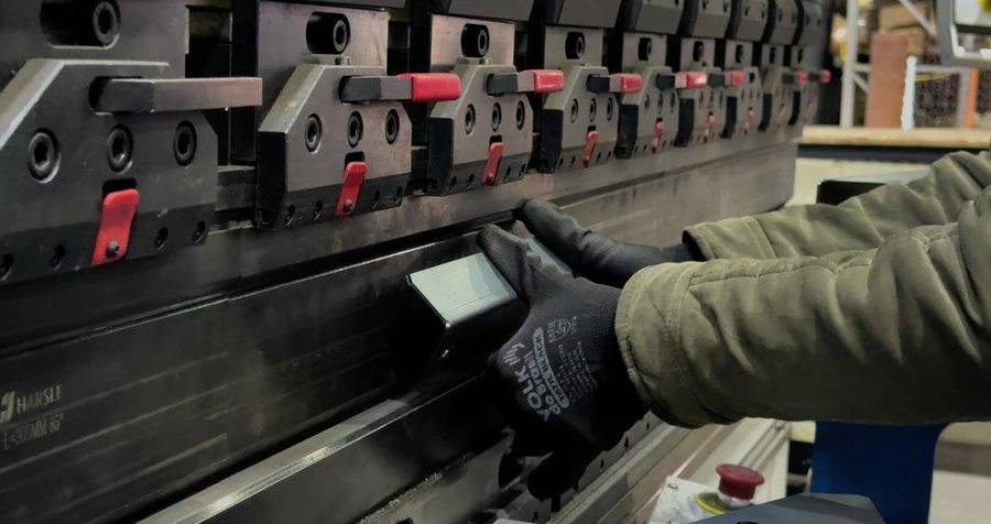 Operador ajustando la plegadora CNC