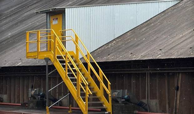 Escalera de acceso amarilla instalada sobre el galpón